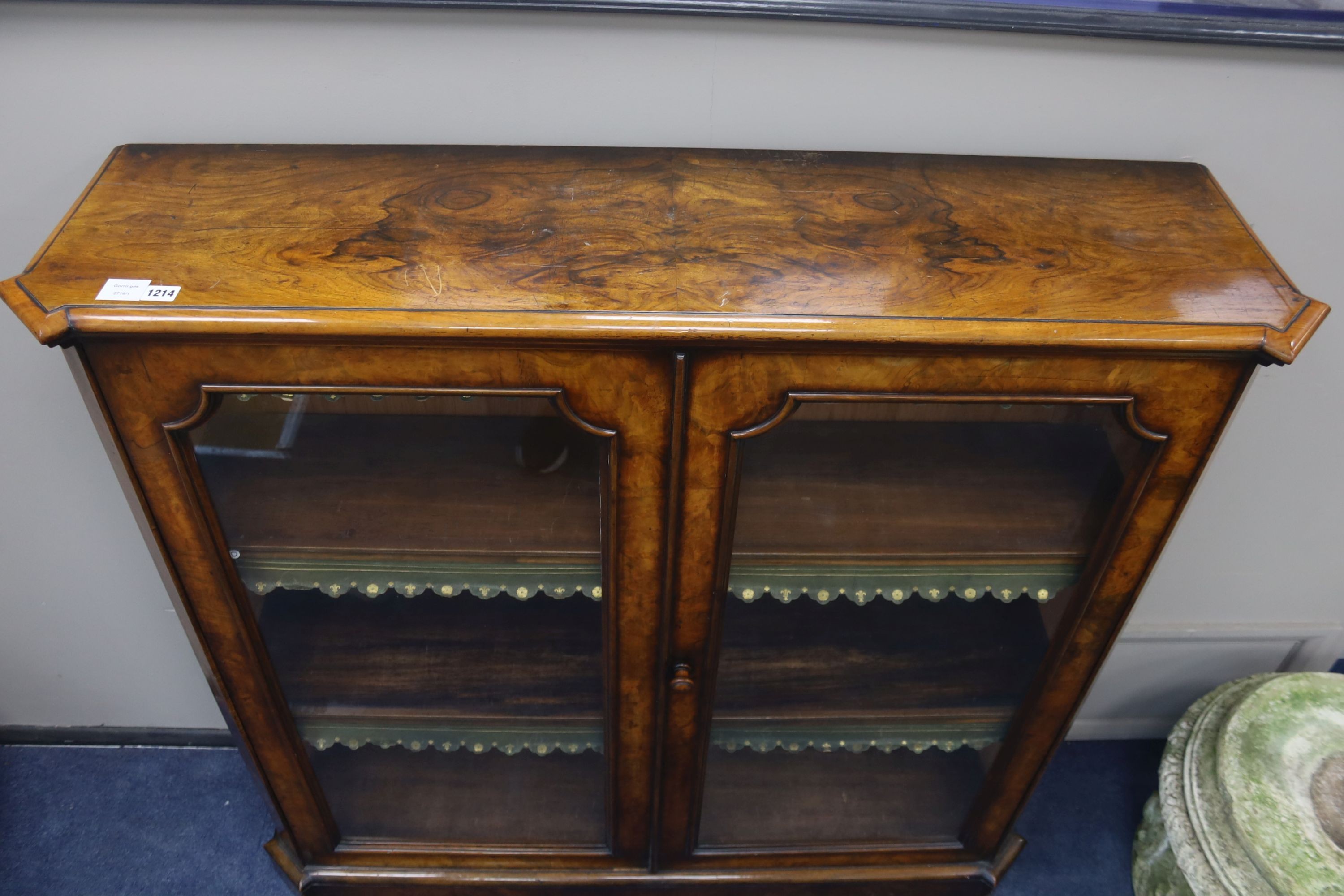 A Victorian walnut veneered bookcase with twin panelled glazed doors, length 126cm, depth 33cm, height 122cm